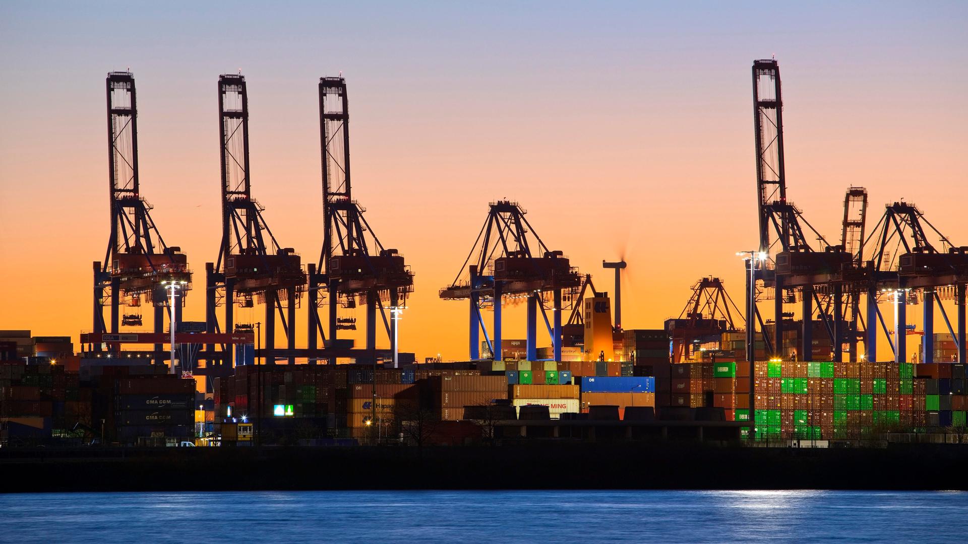 Verladekräne am Containerterminal Burchardkai in Hamburg: Die Sonne geht unter. Verladekräne am Containerterminal Burchardkai in Hamburg: Die Sonne geht unter.